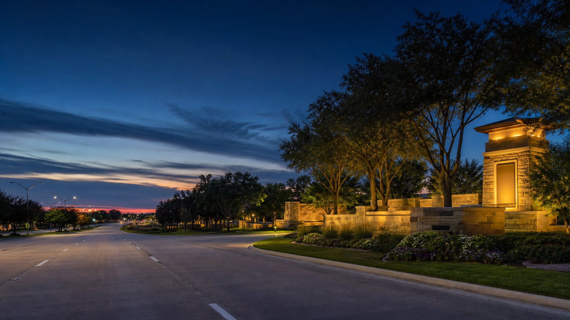 Dusk view of a Cypress, Texas tree-lined suburban road and landscaped entrance